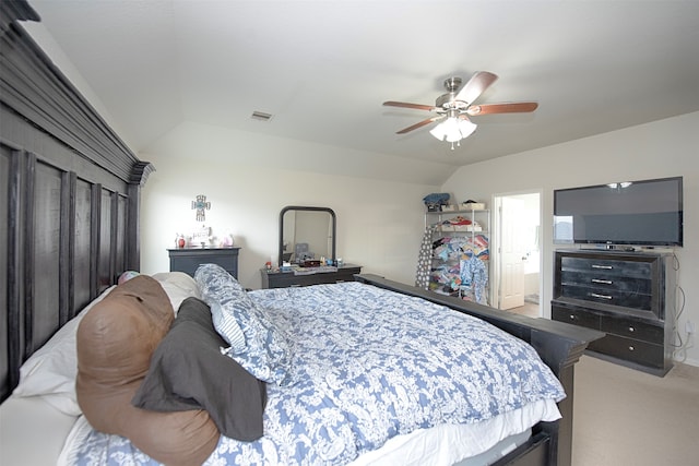 bedroom featuring ensuite bathroom, light colored carpet, ceiling fan, and vaulted ceiling