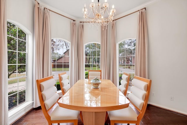 dining room with ornamental molding, dark wood-type flooring, and an inviting chandelier