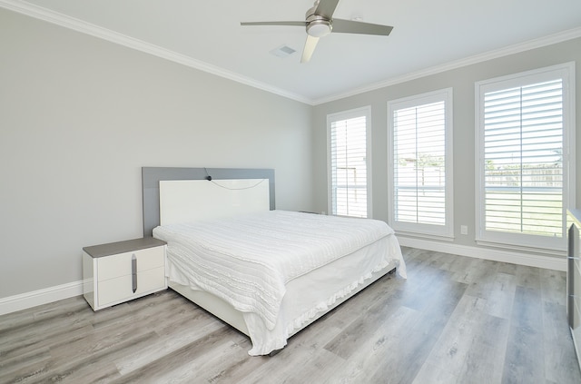 bedroom featuring light hardwood / wood-style floors, ornamental molding, multiple windows, and ceiling fan