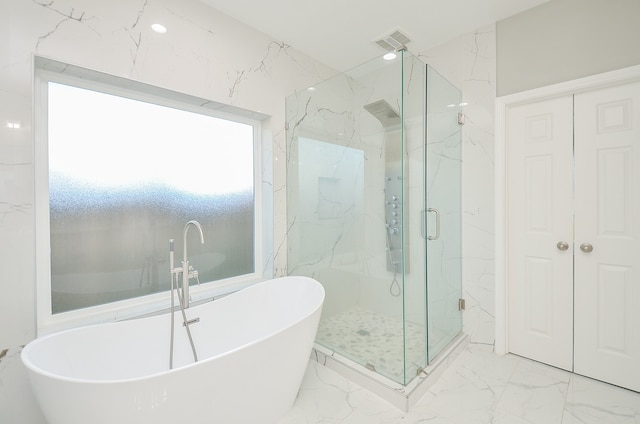 bathroom featuring independent shower and bath