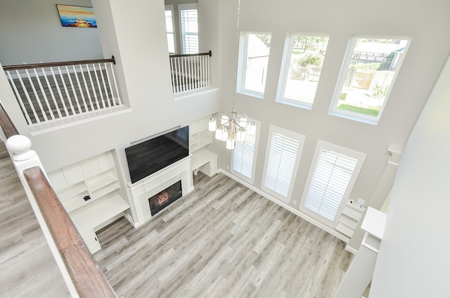 living room with a high ceiling, light hardwood / wood-style flooring, and a notable chandelier