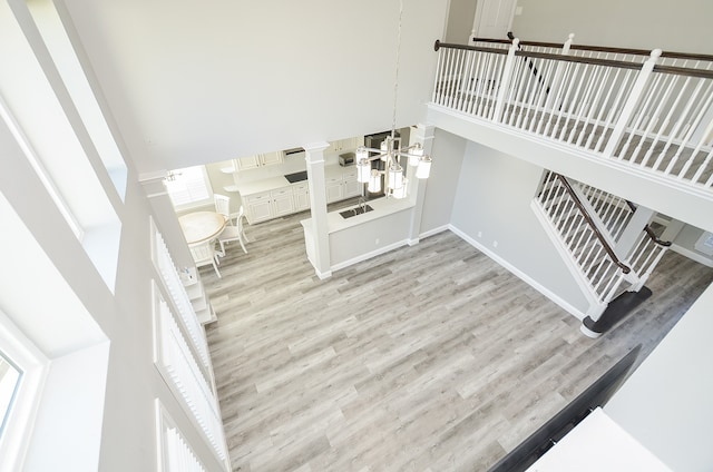 stairs with a healthy amount of sunlight, hardwood / wood-style flooring, and a high ceiling