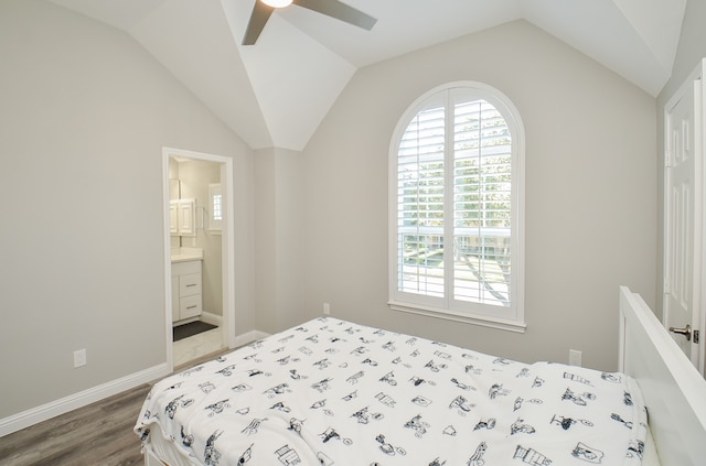 bedroom featuring hardwood / wood-style flooring, ceiling fan, ensuite bath, and lofted ceiling