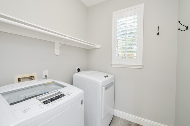 laundry area with light hardwood / wood-style floors and independent washer and dryer