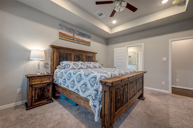 bedroom featuring light carpet, a tray ceiling, and ceiling fan