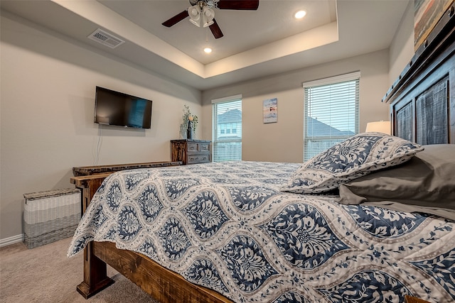 bedroom featuring carpet, a raised ceiling, and ceiling fan