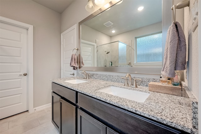 bathroom with tile patterned flooring, vanity, and walk in shower