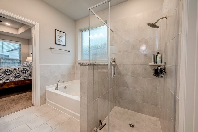 bathroom with shower with separate bathtub and tile patterned floors