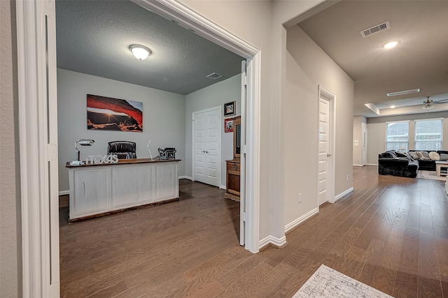 hall featuring a textured ceiling and hardwood / wood-style flooring