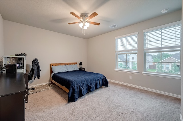 bedroom with ceiling fan and light carpet