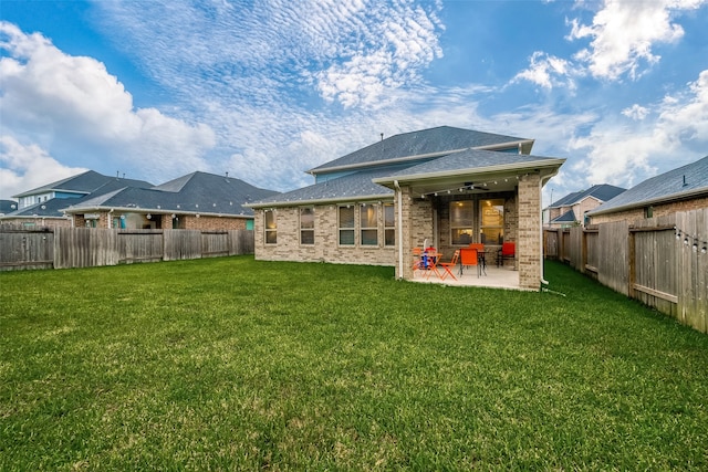 rear view of property with a lawn, ceiling fan, and a patio