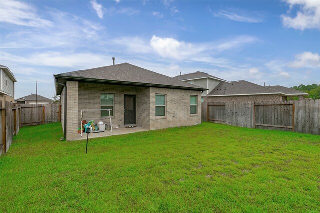 rear view of property with a patio and a lawn