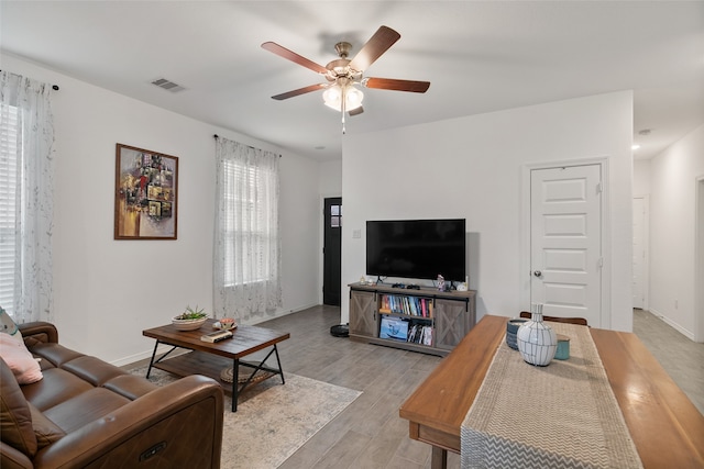 living room featuring a healthy amount of sunlight, light wood-type flooring, and ceiling fan