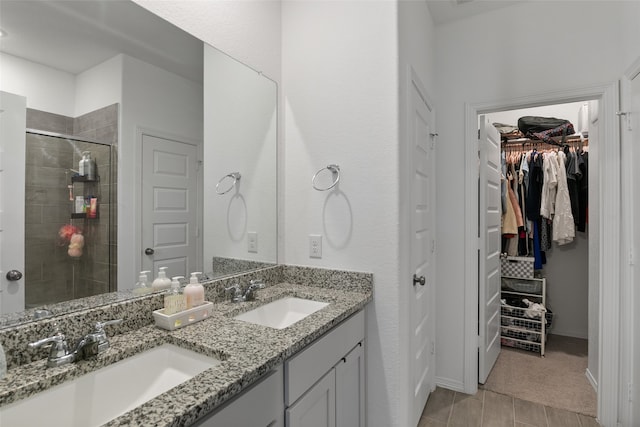 bathroom featuring a shower with door and vanity