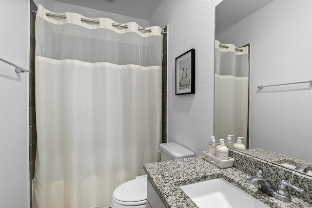 bathroom featuring vanity, toilet, and curtained shower