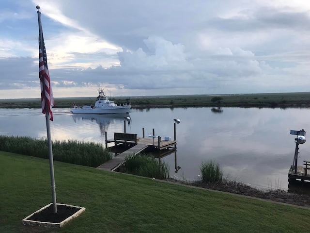 dock area featuring a lawn and a water view