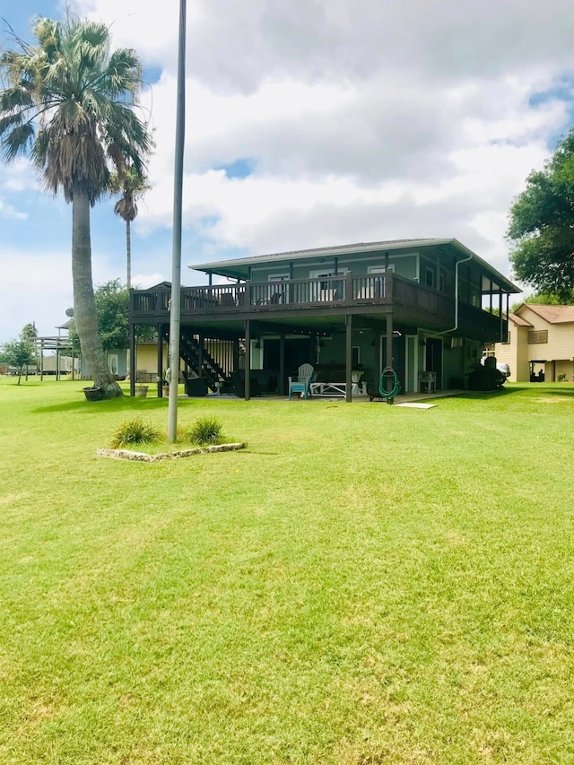 back of property with a lawn and a wooden deck