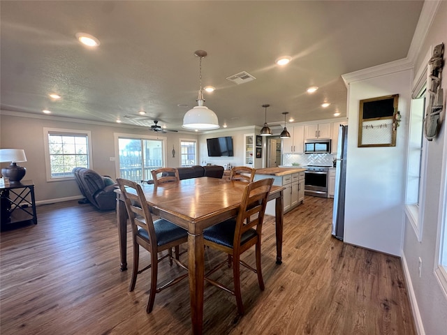 dining room with hardwood / wood-style floors, ceiling fan, and crown molding