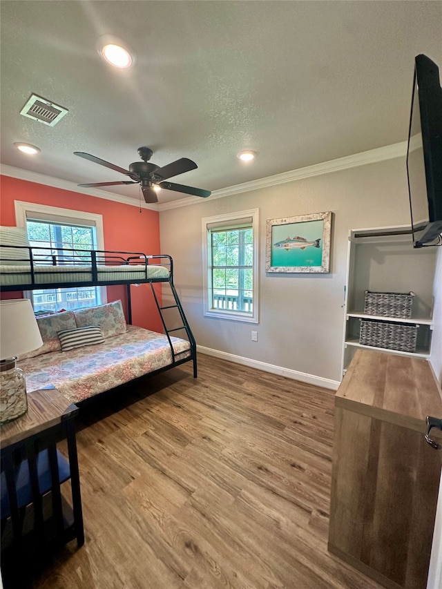 bedroom with ceiling fan, crown molding, and hardwood / wood-style flooring