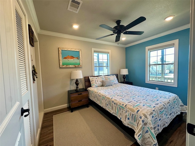 bedroom with dark hardwood / wood-style flooring, ceiling fan, and crown molding