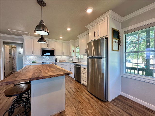 kitchen featuring white cabinets, crown molding, sink, and appliances with stainless steel finishes