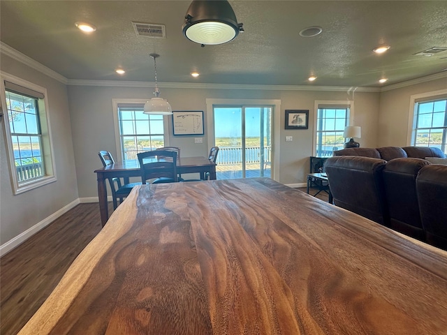 dining area featuring dark hardwood / wood-style floors, ornamental molding, and a textured ceiling