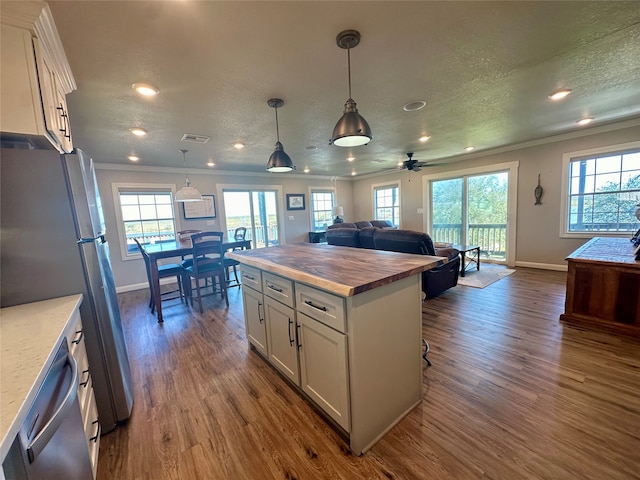 kitchen featuring white cabinets, a kitchen island, and a healthy amount of sunlight