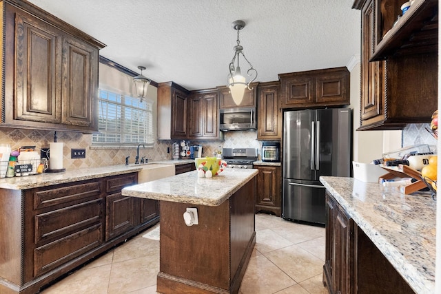 kitchen featuring a center island, appliances with stainless steel finishes, dark brown cabinets, and hanging light fixtures