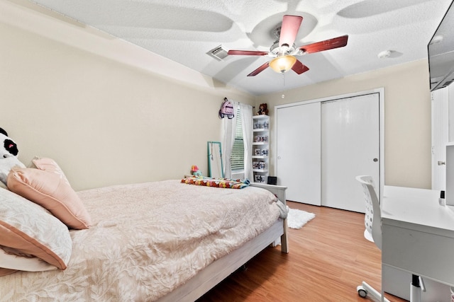 bedroom featuring hardwood / wood-style floors, ceiling fan, a textured ceiling, and a closet