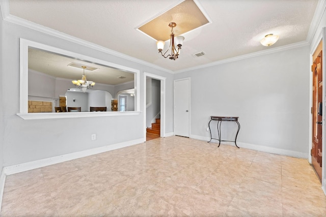 empty room featuring a textured ceiling, an inviting chandelier, and crown molding