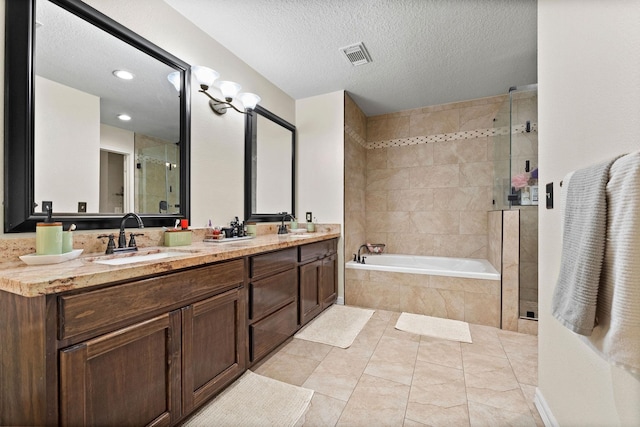 bathroom featuring vanity, independent shower and bath, and a textured ceiling