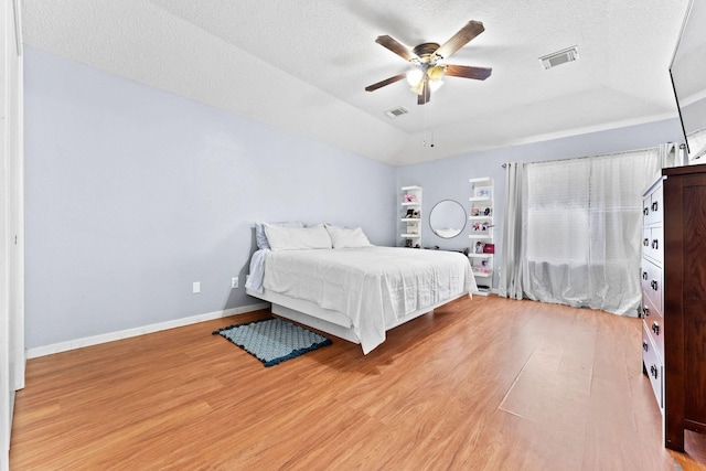 bedroom featuring a textured ceiling, ceiling fan, and light hardwood / wood-style flooring