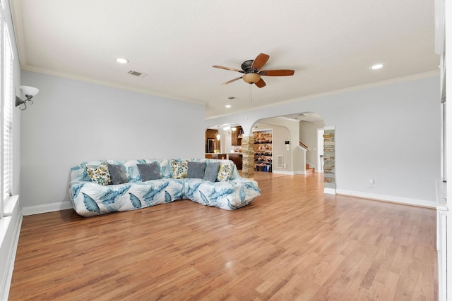 unfurnished living room with ceiling fan, light wood-type flooring, and crown molding