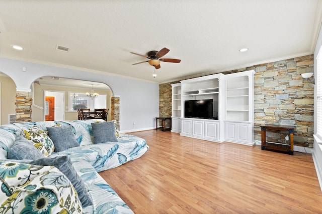 living room with ceiling fan with notable chandelier, light hardwood / wood-style floors, a textured ceiling, and crown molding