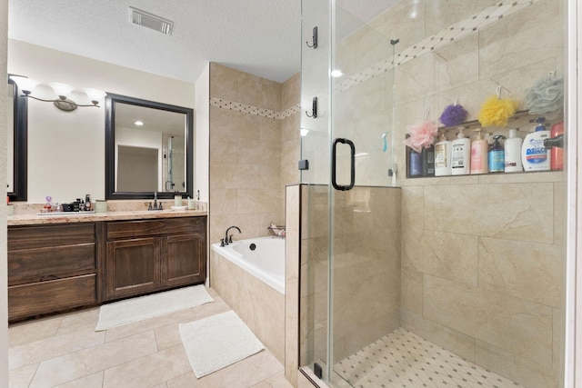 bathroom with vanity, plus walk in shower, a textured ceiling, and tile patterned flooring