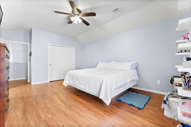 bedroom with ceiling fan, a closet, light hardwood / wood-style flooring, and lofted ceiling