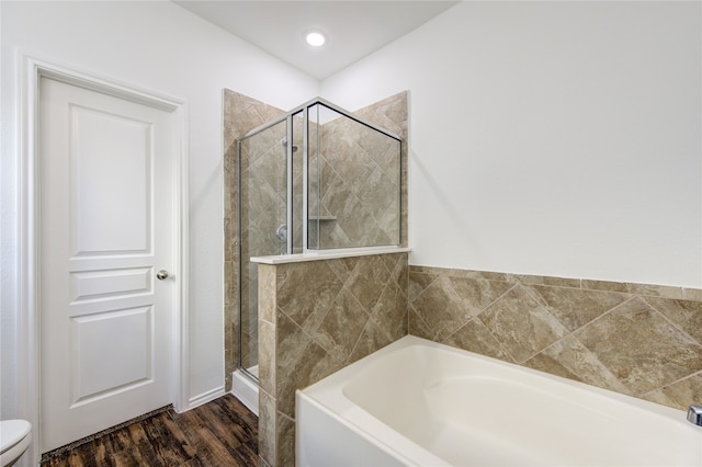 bathroom featuring toilet, hardwood / wood-style floors, and separate shower and tub