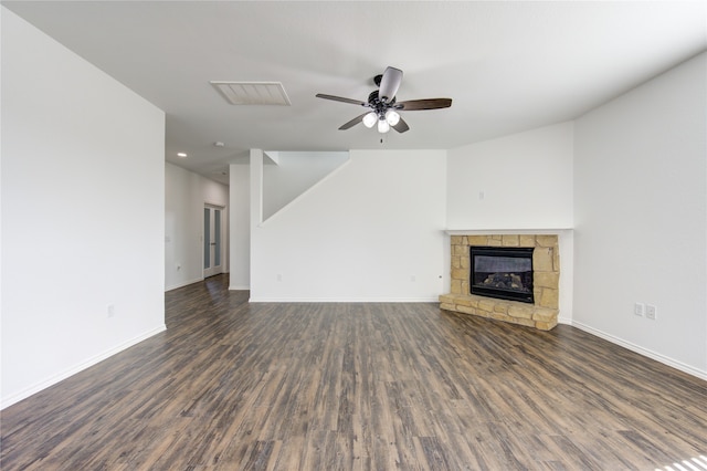 unfurnished living room with ceiling fan, a fireplace, and dark hardwood / wood-style flooring