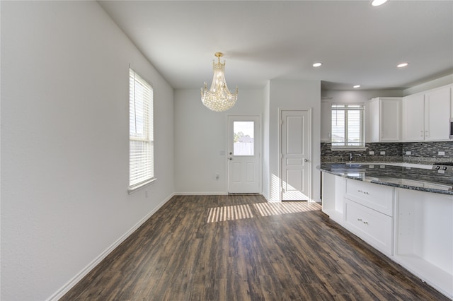 kitchen with decorative backsplash, white cabinets, a healthy amount of sunlight, and dark wood-type flooring