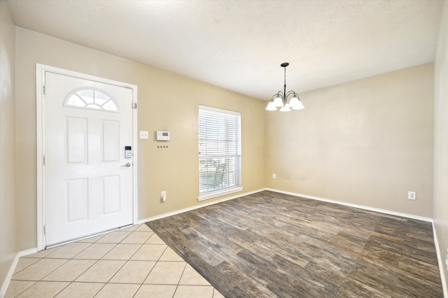 foyer entrance featuring light hardwood / wood-style flooring, a healthy amount of sunlight, and a notable chandelier