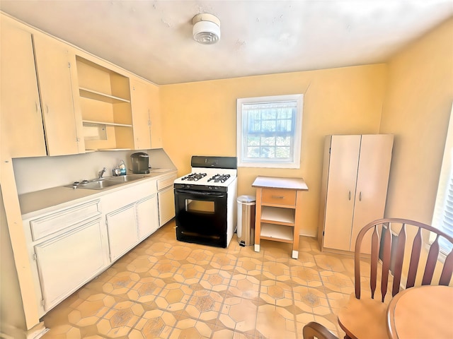 kitchen featuring sink, white cabinets, and gas range gas stove