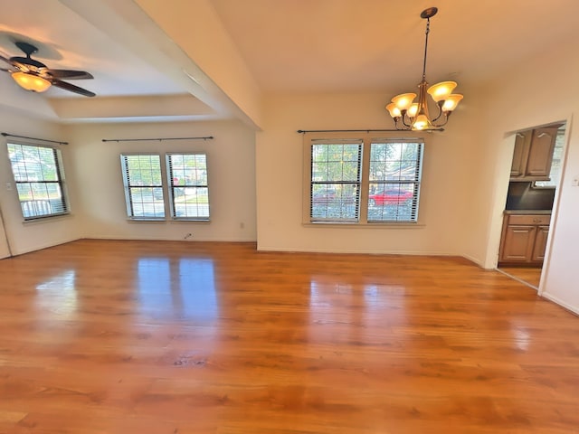 interior space with light hardwood / wood-style floors, ceiling fan with notable chandelier, and a wealth of natural light