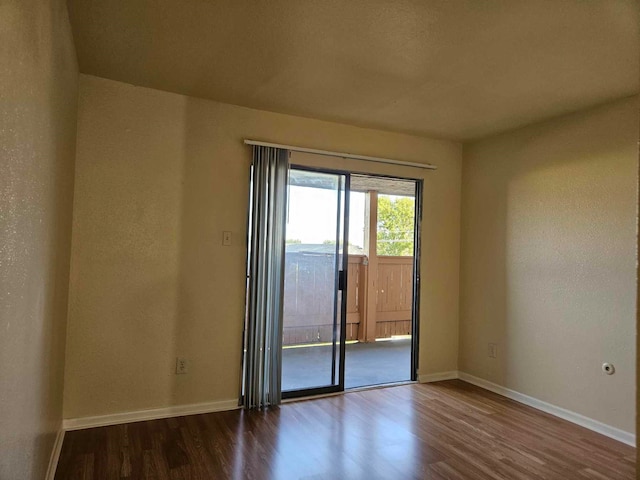 empty room with dark hardwood / wood-style flooring