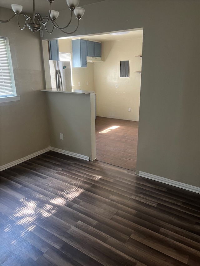 interior space with dark wood-type flooring and a notable chandelier