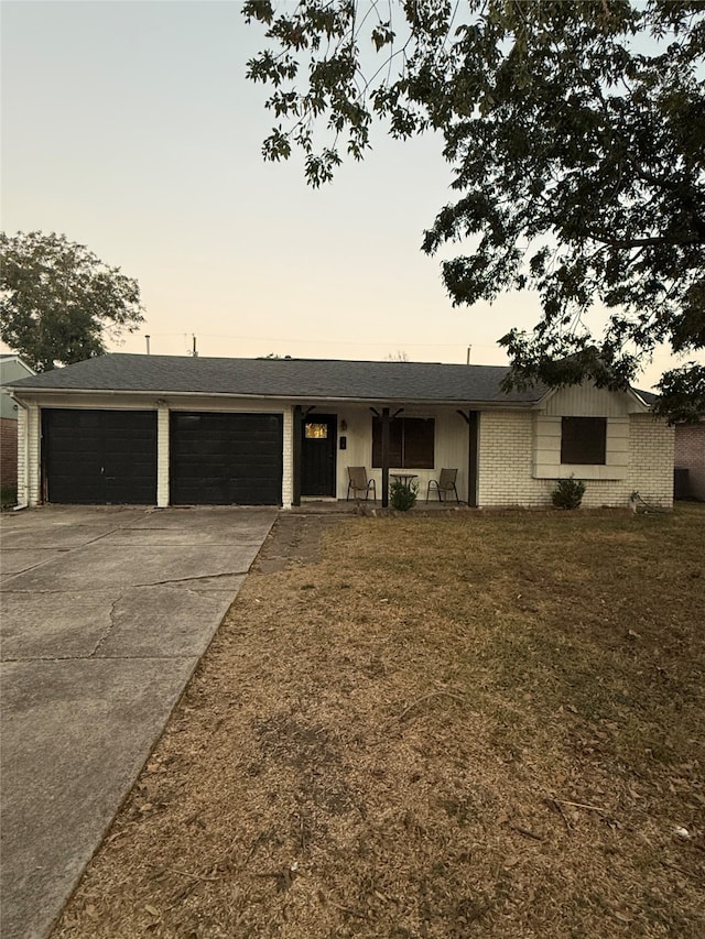 ranch-style home with a yard and a garage