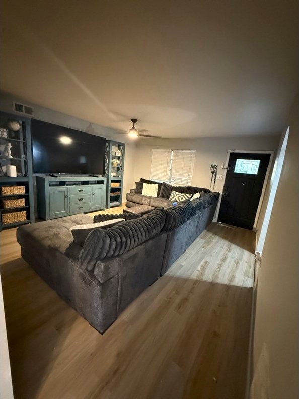 living room featuring light hardwood / wood-style floors and ceiling fan