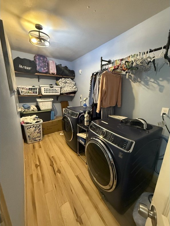 laundry room with washing machine and dryer, laundry area, and wood finished floors