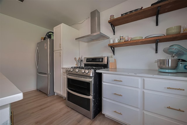 515 Cappamore St, Houston, TX 77013 - kitchen featuring stainless steel appliances, wall chimney exhaust hood, open shelves, white cabinets, and light wood-style floors