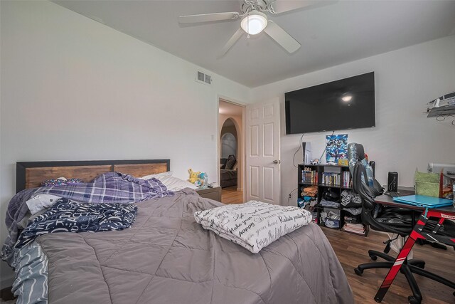 515 Cappamore St, Houston, TX 77013 - bedroom featuring wood finished floors, arched walkways, ceiling fan, and a desk