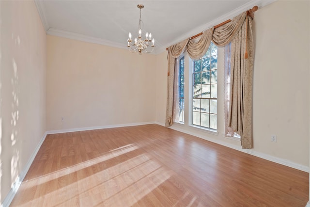 unfurnished room featuring crown molding, light hardwood / wood-style flooring, and an inviting chandelier